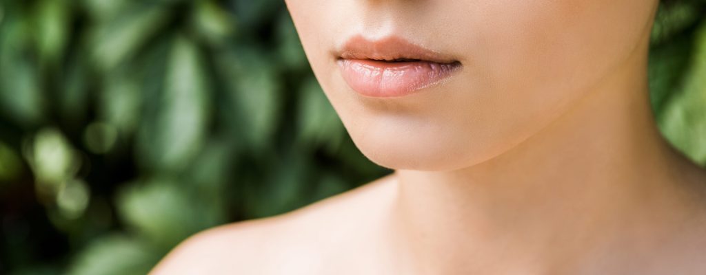 close up of female lips with green background