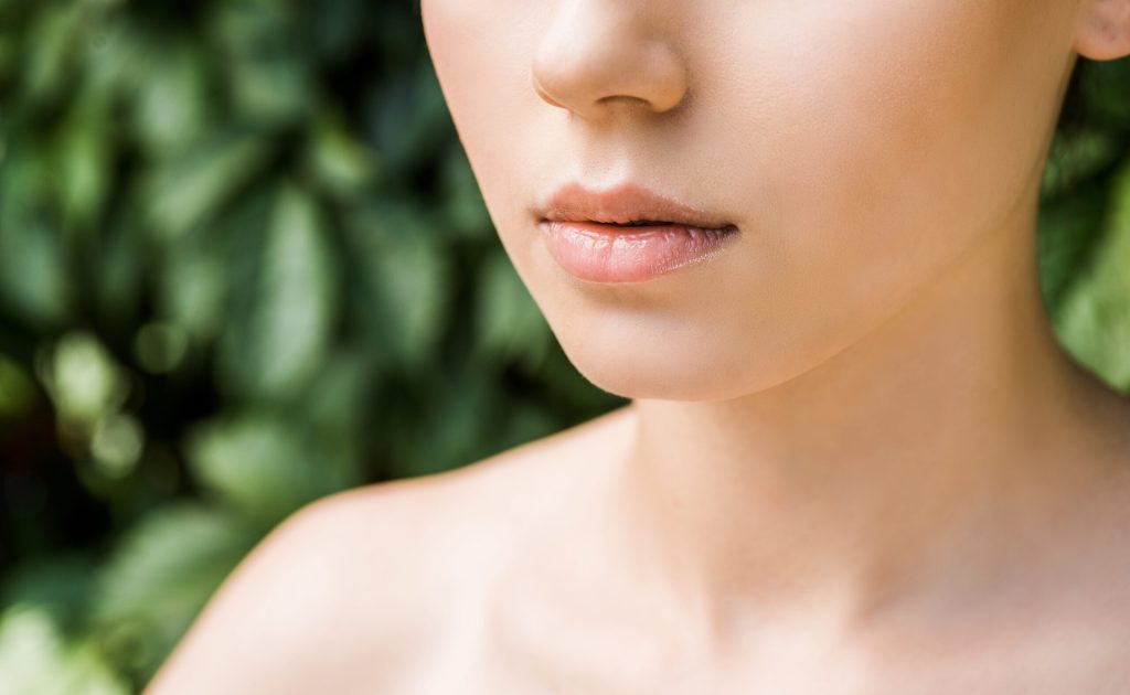 close up of female lips with green background